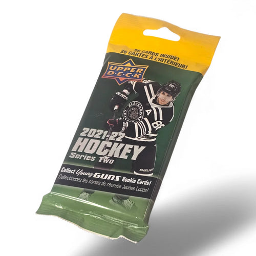 A sealed original retail packaging of 2021-22 Upper Deck Series 2 Hockey Fat Pack featuring a green color scheme with images of hockey players and a referee on the front.