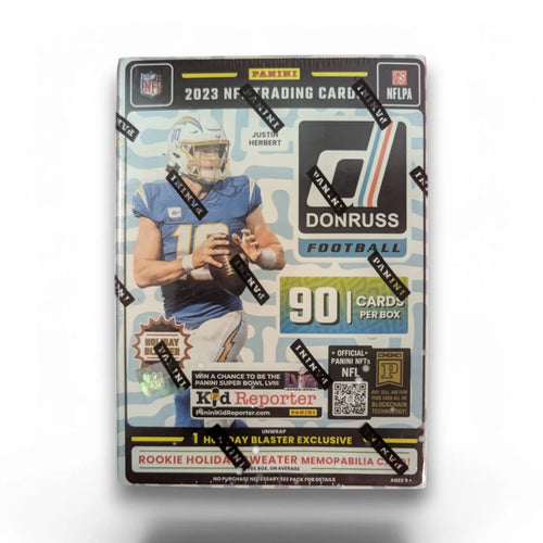 A sealed blaster box of 2023 Panini Donruss Football cards featuring images of NFL players and holiday-themed graphics.